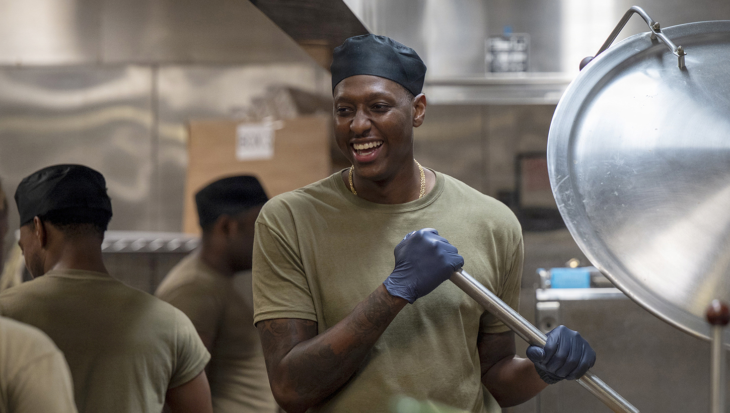 Air Force Senior Airman James Cawley, 94th Force Support Squadron food services technician, smiles while stirring food
