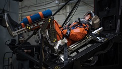 A U.S. Air Force volunteer tests the next replica of a space suit and seat for the Orion spacecraft in the vertical deceleration tower