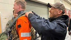 Aviation Warfare Systems (AWS) crewman is fitted with blast overpressure monitoring equipment prior to a GAU-21 heavy machine gun exercise aboard an MH-60S helicopter in February 2023