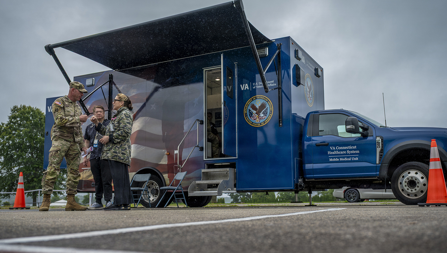  A Soldier assigned to the Connecticut National Guard's 1st Battalion, 102nd Infantry Regiment talks with a member of the Connecticut Department of Veterans Affairs Mobile Medical Team