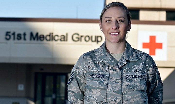 U.S. Air Force Staff Sgt. Cassidy McCurdy, 51st Medical Group independent medical duty technician, poses for a photo at Osan Air Base, South Korea. McCurdy has more than five years of experience in the medical field including two years as an IDMT. On a flight from San Francisco to Seattle she responded to a passenger, who went into cardiac arrest, by providing cardiopulmonary resuscitation and stabilizing the passenger. Once the aircraft landed, emergency responders from the ground transported the patient to the emergency room. (U.S. Air Force photo by Staff Sgt. Franklin R. Ramos)