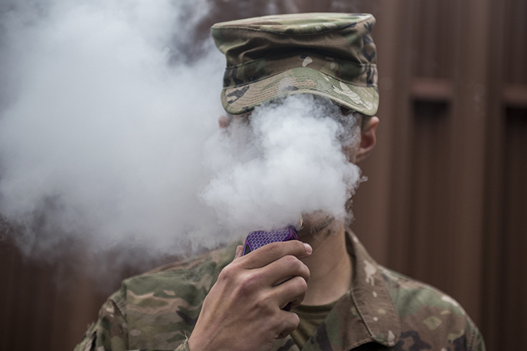 A Team Offutt Airman vapes in an authorized smoking area during a break Nov. 7. As of Oct. 29, 2019, over 1,800 lung injury cases and 37 deaths have been reported to the Centers for Disease Control and Prevention and the only commonality among all cases is the patient’s use of e-cigarette or vaping products. Offutt Airmen looking for support quitting can schedule an appointment with a behavioral health consultant or primary care manager by calling 402-232-2273. To schedule a unit briefing on the dangers of vaping and options for quitting, call 402-294-5977. Outside assistance, including text-message support, is available by visiting www.smokefree.gov, www.thetruth.com or www.ycq2.org.  