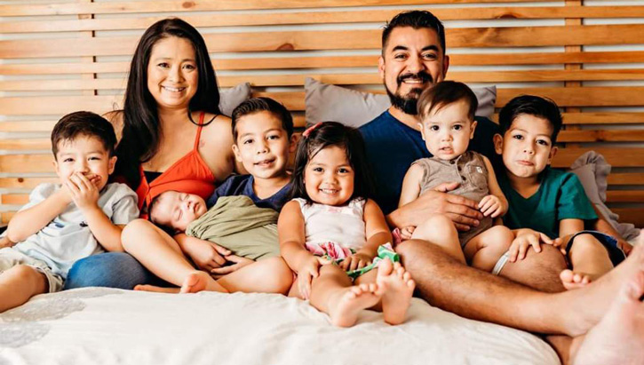 Image of Retired U.S. Marine Corps Gunnery Sgt. Carlos Hernandez and his wife, Ashley, take a family portrait with their six children. Ashley is BAMC’s first patient to give birth while on Extracorporeal Membrane Oxygenation. .