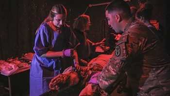 he photo displays teachers from Northwest High School's Health Science Academy, part of the Montgomery County School System in Tennessee, touring the hospital’s educational and staff department. Assisted by combat medics, the teachers experienced firsthand the intensity of managing simulated patients, with realistic red lights and strobe effects enhancing the training environment.
