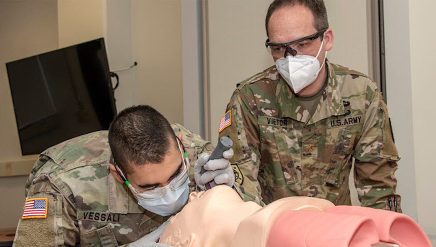 Army (then) Maj. Robert Vietor, right, watches as a Navy student practices bag-mask ventilation on an airway trainer during Transition to Clerkship airway skills training