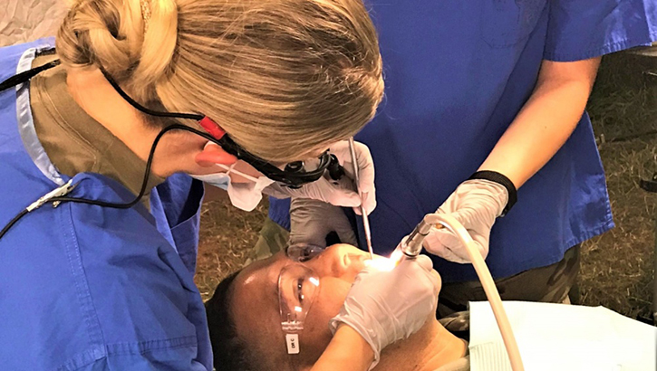 Army dentist, Capt. Cierra Diamse, a general dentist assigned to the Wiesbaden Dental Clinic, performs dental work on a soldier during a field training exercise held recently at Baumholder, Germany. Following the 9 Ways to RUIN Your Dental Fitness assures a scene like this downrange. (U.S. Army photo by Kirk Frady)