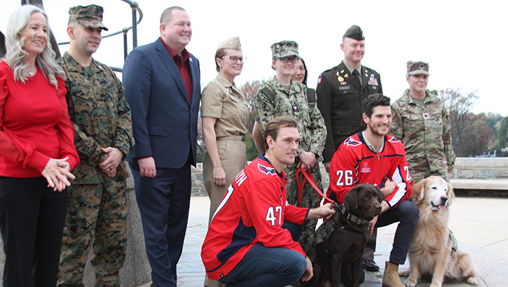 Biscuit, a chocolate-colored Labrador Retriever, is congratulated by Walter Reed leadership, service members, Washington Capitals players and others upon joining the Walter Reed Facility Dog Program and being awarded the honorary title of U.S. Marine Corps Corporal during an enlistment ceremony on Tuesday, Nov. 7, at Walter Reed. (Photo By Bernard Little