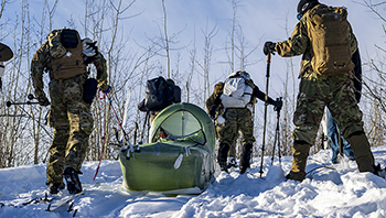 U.S. East Coast-based Naval Special Warfare, U.S. Army, Canadian, U.K., and interagency Special Operations Forces transport a casualty during Special Operations Forces Arctic Medic 2025 at Fort Wainwright, Alaska