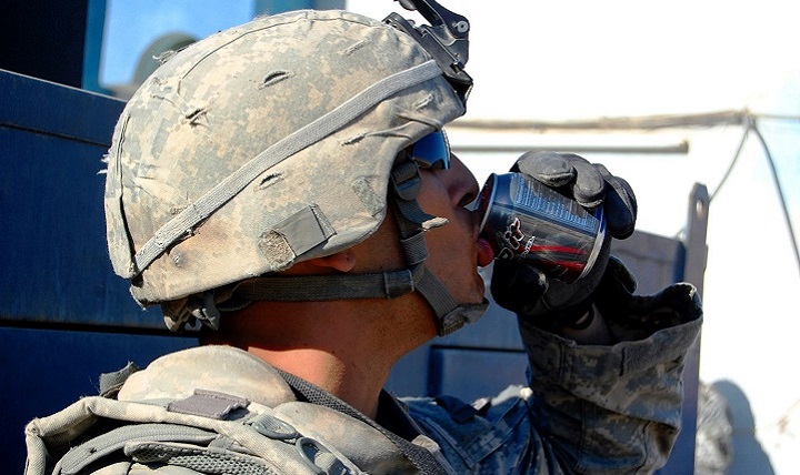 A soldier drinks an energy drink before his patrol in Iraq. 