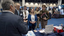 Senior leaders with the Defense Health Agency tour the Research, Development, and Acquisition/Component Acquisition Executive office (AD-RDA/CAE) display during the Military Health System Research Symposium