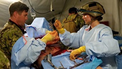Cmdr. Ryan Schutt (left), surgeon, and Hospital Corpsman 2nd Class Ella Semerad (right), surgical technologist, assigned to Expeditionary Resuscitative Surgical System (ERSS) 12, Navy Medicine Readiness and Training Command Camp Lejeune, North Carolina, conduct a surgical procedure on a simulated casualty during ERSS training 