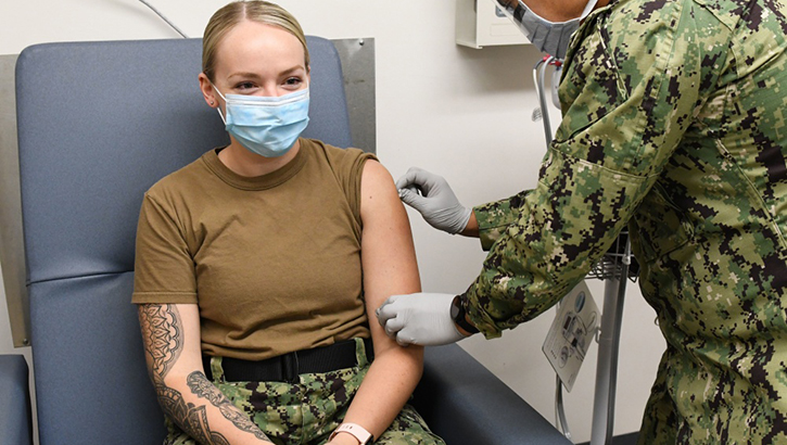Soldier giving another soldier a flu shot