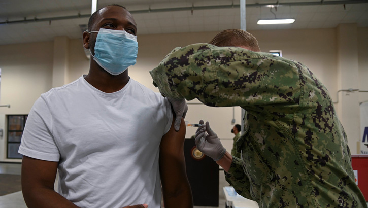 A hospital corpsman administers an influenza vaccination to an airman as part of a seasonal shot exercise onboard Naval Air Station Sigonella.