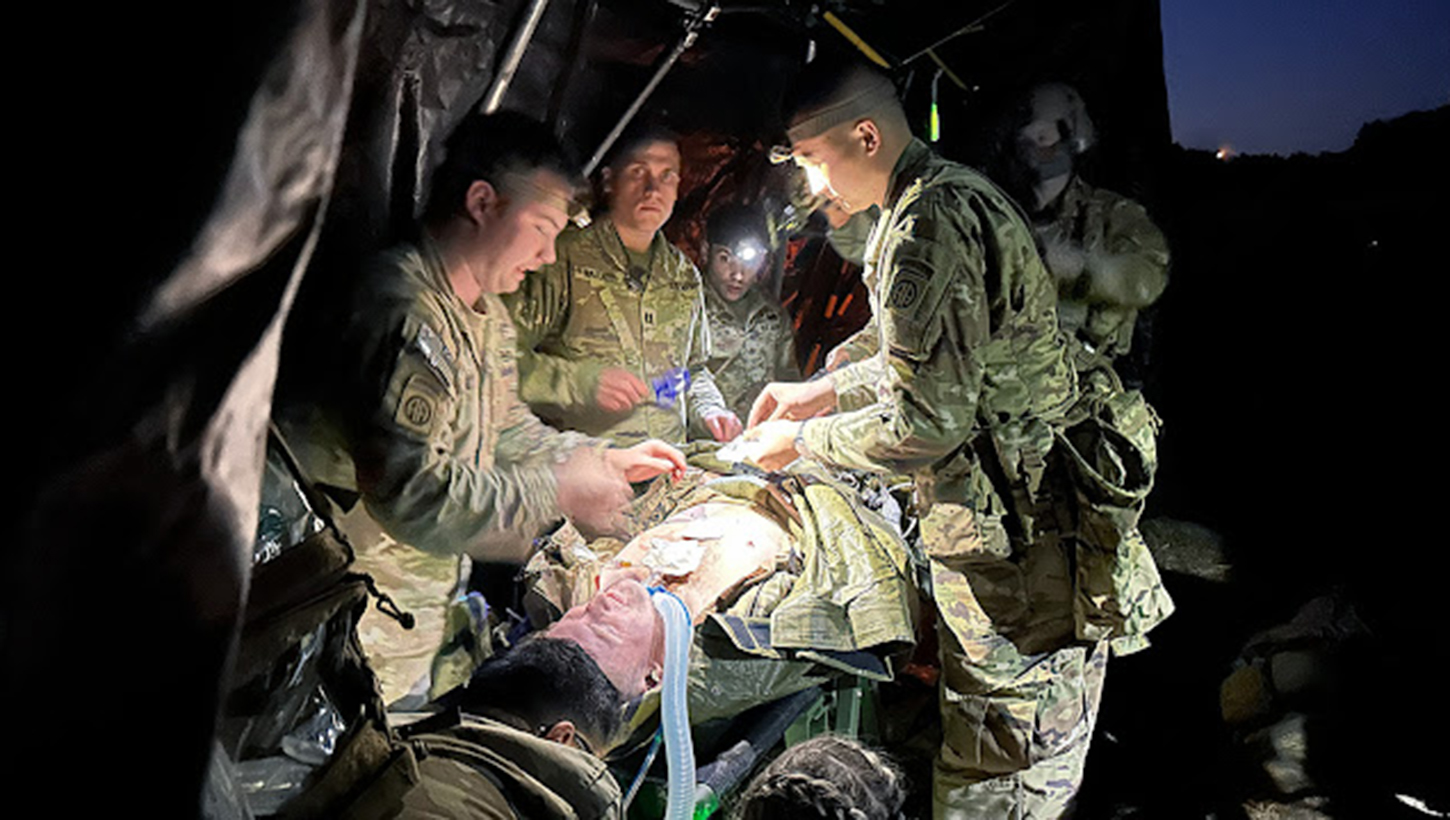 Soldiers with the 82nd Airborne Division treat a simulated casualty during a nighttime field training exercise
