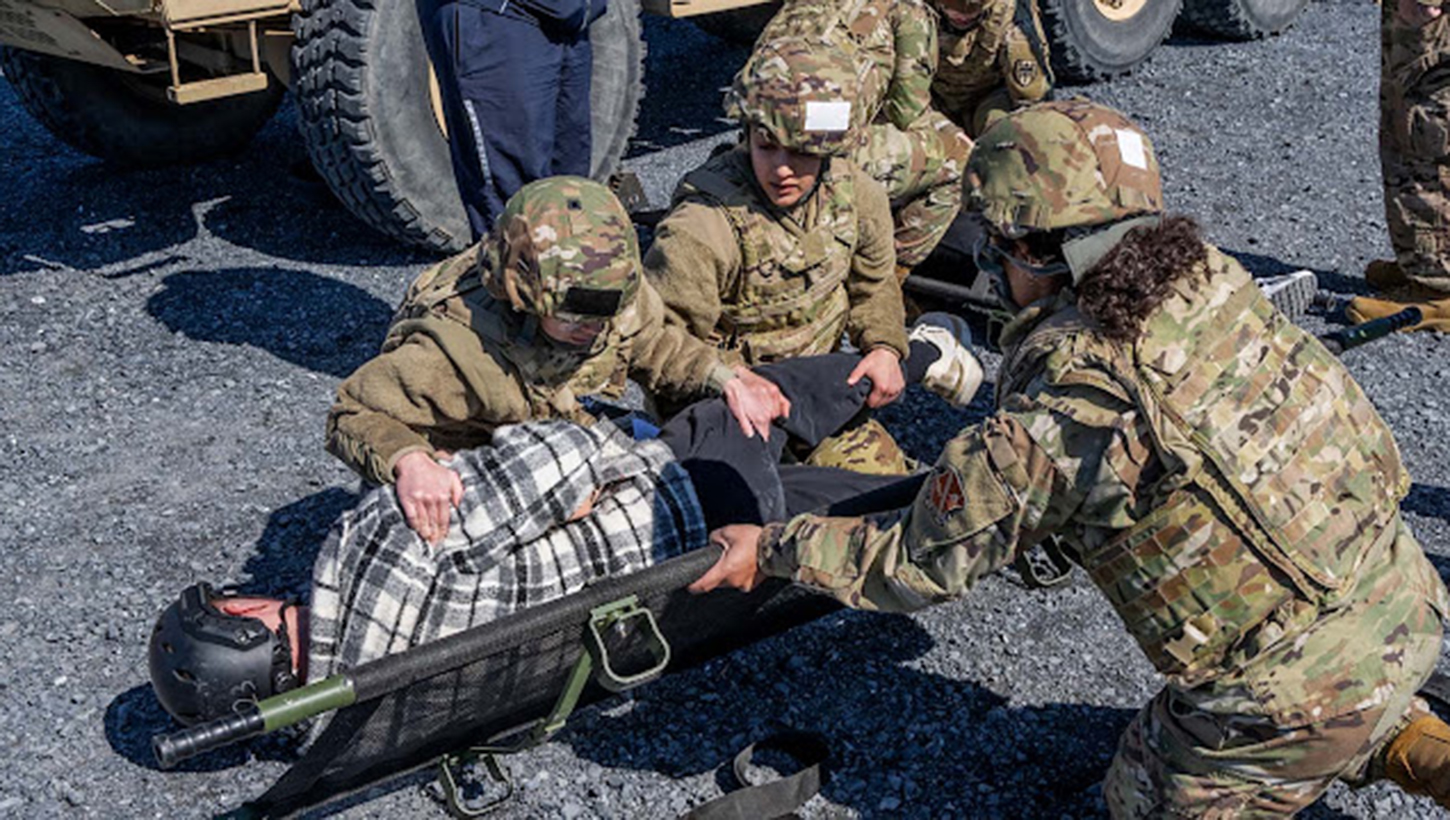 USU students move a simulated casualty onto a litter during the university's Gunpowder field exercise.