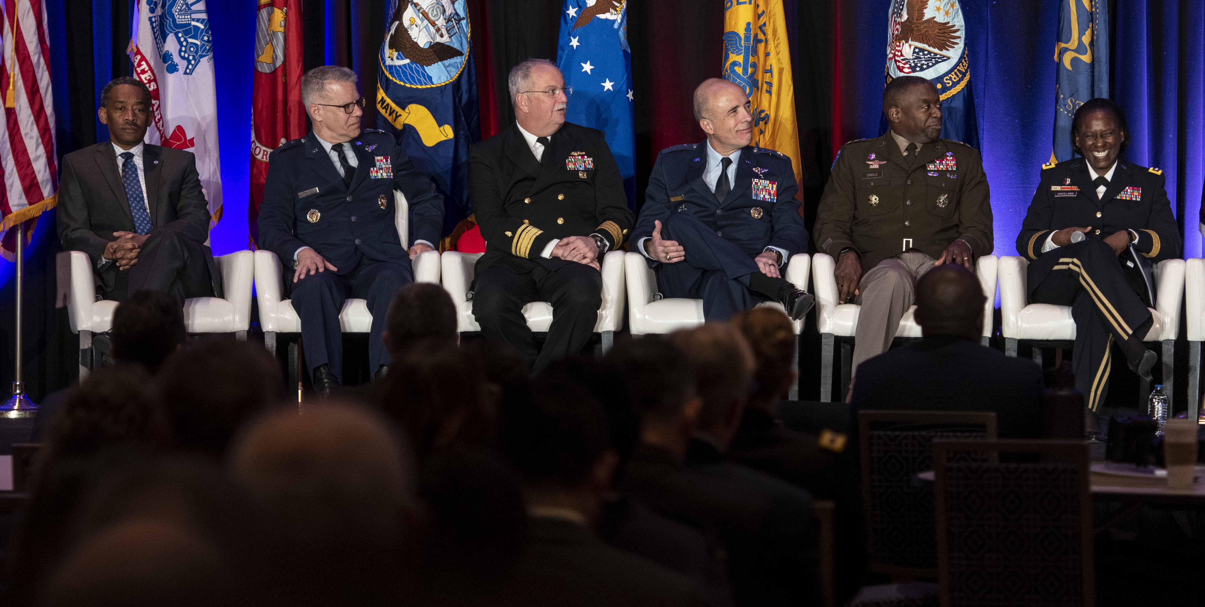 Image of Uniformed Services University President Jonathan Woodson, U.S. Air Force Major General Paul Friedrichs, U.S. joint staff surgeon, U.S. Navy Surgeon General Rear Adm. Bruce Gillingham, U.S. Air Force Surgeon General Lt. Gen. Robert Miller, U.S. Army Surgeon General Lt. Gen. Scott Dingle, and Defense Health Agency Director U.S. Army Lt. Gen. Telita Crosland answer questions during a panel discussion on Feb. 14 during the 2023 AMSUS Annual Meeting in National Harbor, Maryland. The panel was titled, “Collaboration Across and Outside the MHS Today and Tomorrow.”.