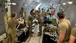 A U.S. Air Force CCATT from BAMC provides simulated medical care to a patient inside a KC-46 Pegasus during a readiness exercise