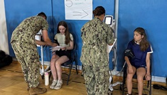 Lt. Vanessa Bernales and Hospital Corpsman 3rd Class Benjamin Mason conduct blood pressure screenings for Department of War Education Activity (DoWEA) student athletes during a sports physical rodeo