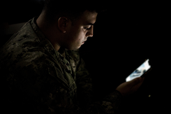 Photo by Petty Officer 1st Class Benjamin Lewis, Naval Station Rota, Spain, of a Yeoman 2nd Class reading his mobile phone in the dark. 