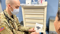 Military health personnel speaking with a patient