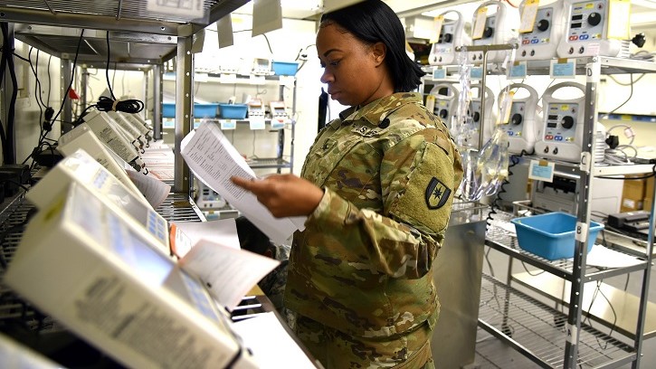 Soldier looking at medical equipment on shelves