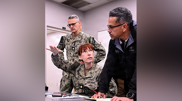U.S. Navy Lt. Cmdr. Erik Lawrence, left, U.S. Navy chief nursing informatics officer for Joint Operational Medicine Information System (JOMIS) assigned to U.S. Navy Bureau of Medicine and Surgery, Lt. Cmdr. Elise Brandon, assigned to Naval Medical Forces Atlantic, and Joe Espinosa from the JOMIS Program Office, discuss the data seeding process in the JOMIS Operational Medicine Care Delivery Platform