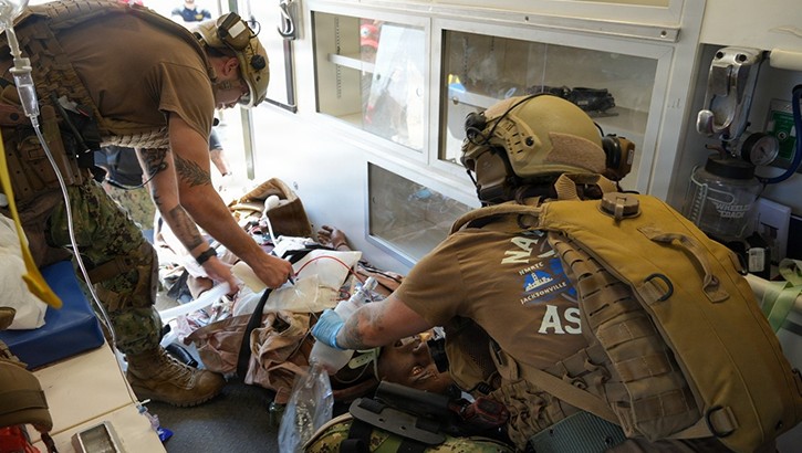 Hospital Corpsman 3rd Class Levi Kim, paramedic (left), and Lt. j.g. Lawannah Cumby, critical care nurse (right), both assigned to En Route Care System (ERCS) 18 from Navy Medicine Readiness and Training Command (NMRTC) Portsmouth, provide medical intervention to a simulated casualty in the back of an ambulance