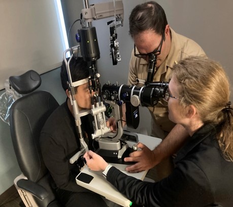 A Transitional Year (TY) resident practices slit lamp examination on a fellow TY resident with the Ophthalmology Chief Resident