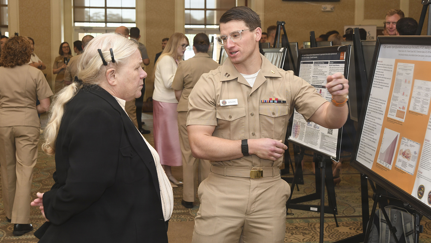 Navy Lt. Robert Goldin with NMCCL Family Medicine Residency Program discusses his research poster at the NMCCL's Annual Research Symposium