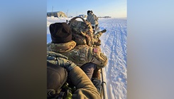 Members of the New Hampshire Army National Guard Medical Readiness Detachment participating in Operation Arctic Care ride in a sled