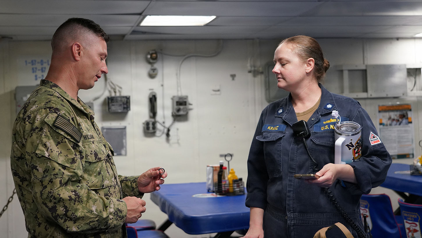 Lt. Cmdr. Brain Williams of Naval Health Research Center (NHRC) discusses wearable devices capabilities with USS Essex (LHD-2) operations officer, Cmdr. Julia Kranz. 