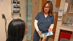 Naval Branch Health Clinic Mayport OB-GYN provider Nurse Practitioner Xiomara Lemmey shares educational material with a patient 