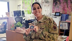 U.S. Air Force Capt. Zanetta Foster holds a coin she received from the Air Combat Command Surgeon General, Col. Raymond J. Clydesdale, for improving standard procedures in the labor and delivery unit at Mike O’Callaghan Military Medical Center