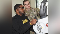 Occupational Therapy Assistant U.S. Army Sgt. Nathan Brunnquell (right) works with Tramel Westbrook on a stationary hand cycle in the Outpatient Occupational Therapy Clinic at Walter Reed. 