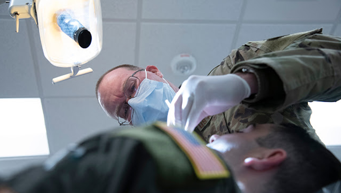 Air Force Lt. Col. Rory Fredrick, a dentist with the 134th Medical Group, Tennessee Air National Guard, performs a routine exam on a member 