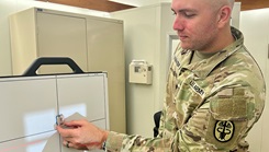 8Spc. Johnny Rainwater, a radiology specialist at Bayne-Jones Army Community Hospital, positions a patient for an X-Ray during a staged photo session