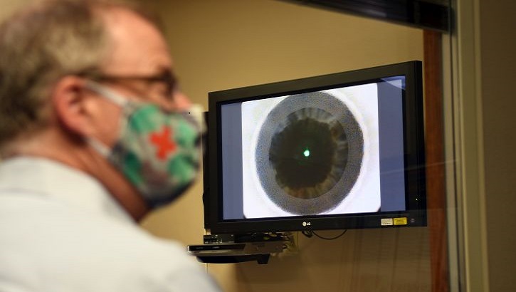 Image of Mr. McCaffery looking at a monitor with an eye on it. Click to open a larger version of the image.