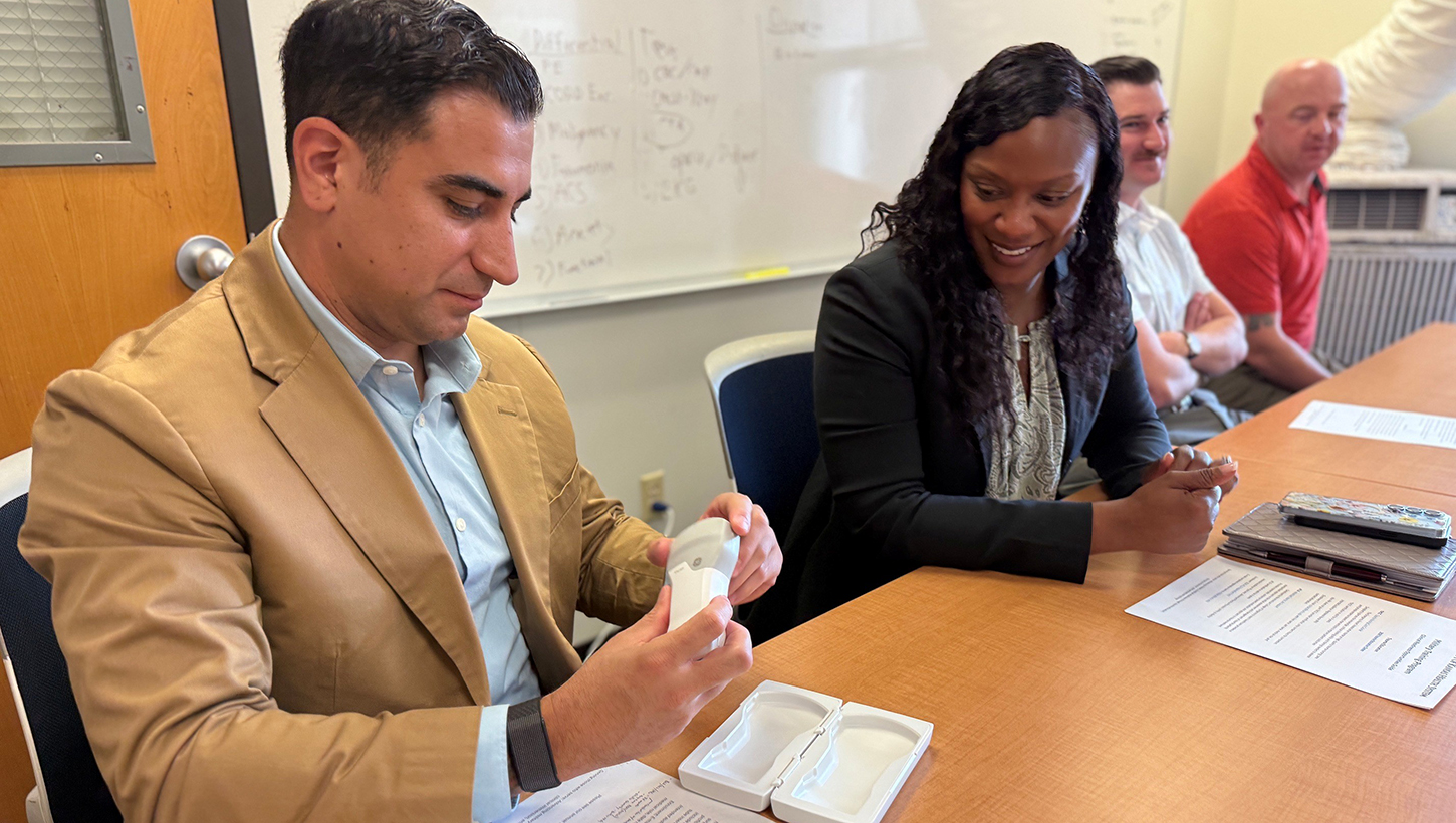 Munson Army Health Center Senior Enlisted Advisor Sgt. Maj. Jason Trevino examines a wireless ultrasound device used by participants 