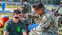 Capt. Jarrod Howell and Sgt. 1st Class Mk-Ada-Quet Generaux, both Observer Coach Trainers with 4th Cavalry Brigade, Division East, First Army out of Fort Knox, Kentucky, treat a simulated heat casualty during the Safety Lane. (Photo by Staff Sgt. Raquel Birk)