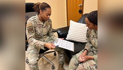 U.S. Air Force Senior Airman Yasmin Freckleton refers to an intake form while speaking with a fellow Airman in a mental health clinic at Ali Al Salem Air Base, Kuwait