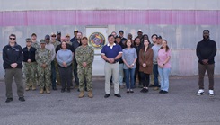 The NMRLC Transportation Directorate team members stand between two of the command's 18-wheeler vehicles