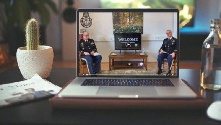 Image of a laptop on a table, with two chaplains on the laptop conducting a virtual service