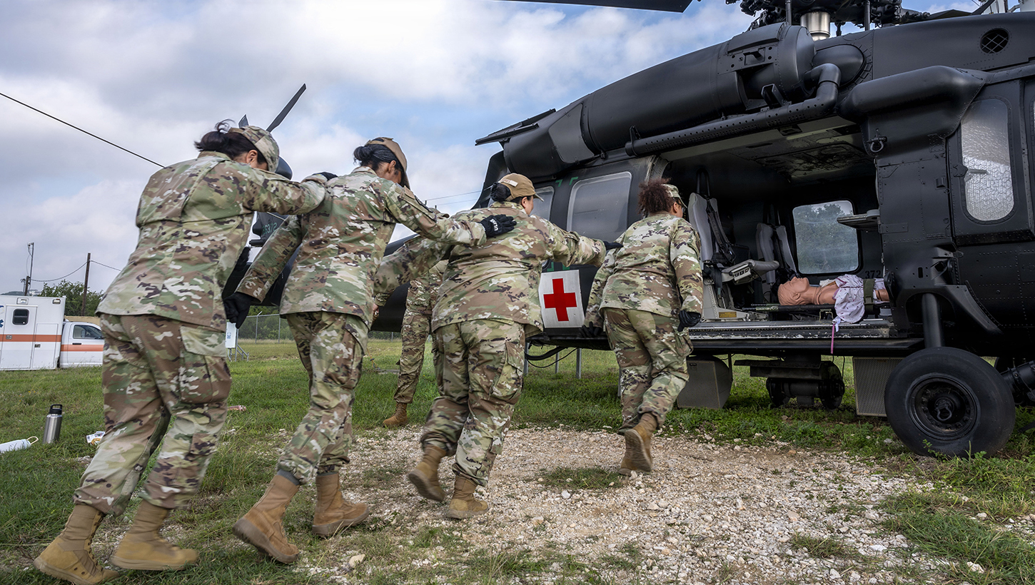 U.S. Air Force students, participating in the Aeromedical Evacuation Patient Staging Course with the 937th Training Squadron, are practicing how to safely approach a HH60M Black Hawk medical evacuation helicopter frame