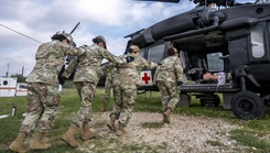 U.S. Air Force students, participating in the Aeromedical Evacuation Patient Staging Course with the 937th Training Squadron, are practicing how to safely approach a HH60M Black Hawk medical evacuation helicopter frame