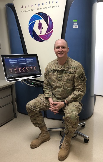 Army Colonel Jon Meyerle, sits in front of a total body digital skin imaging system. The system takes standardized, full-body photographs of patients to help track changes in skin conditions over time. Images can be assessed by a patient’s medical provider at a later date. (Courtesy Photo)