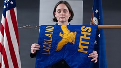 U.S. Air Force Col. Shawn Garcia, commander of the Lackland Medical Group, unfurls the newly activated Lackland Mental Health Squadron guidon during an activation ceremony