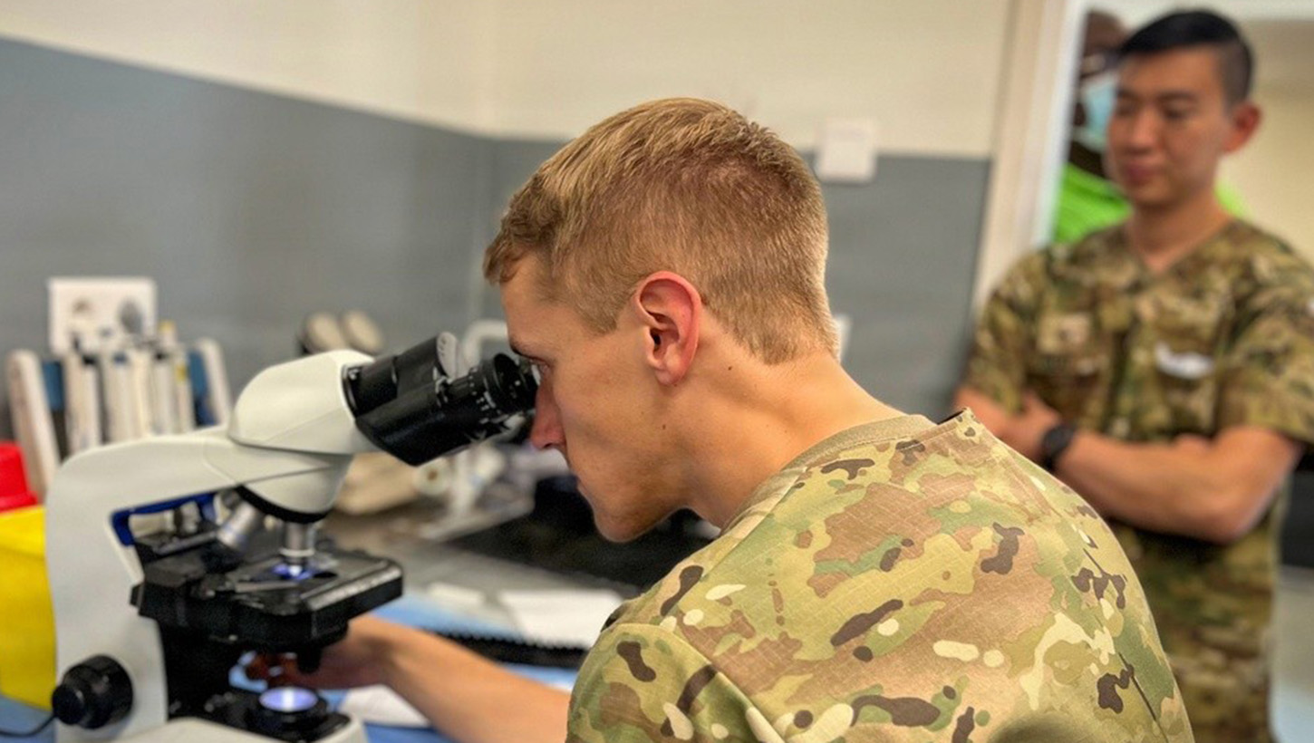 Photo of U.S. Army Sgt. Jacob Smith examining a blood sample 