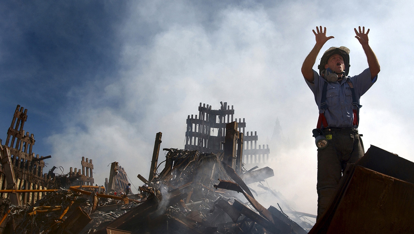 Photo of Firefighter atop of 9/11 rubble