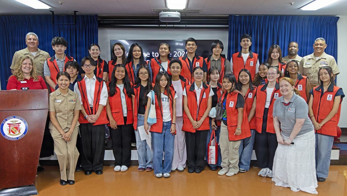 Capt. Joshua Miller, commanding officer of U.S. Navy Medicine Readiness and Training Command (USNMRTC) Yokosuka and director of U.S. Naval Hospital (USNH) Yokosuka, and American Red Cross staff pose for a group photo with the summer VolunTEEN participants