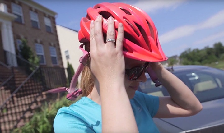 Woman putting on bike helmet